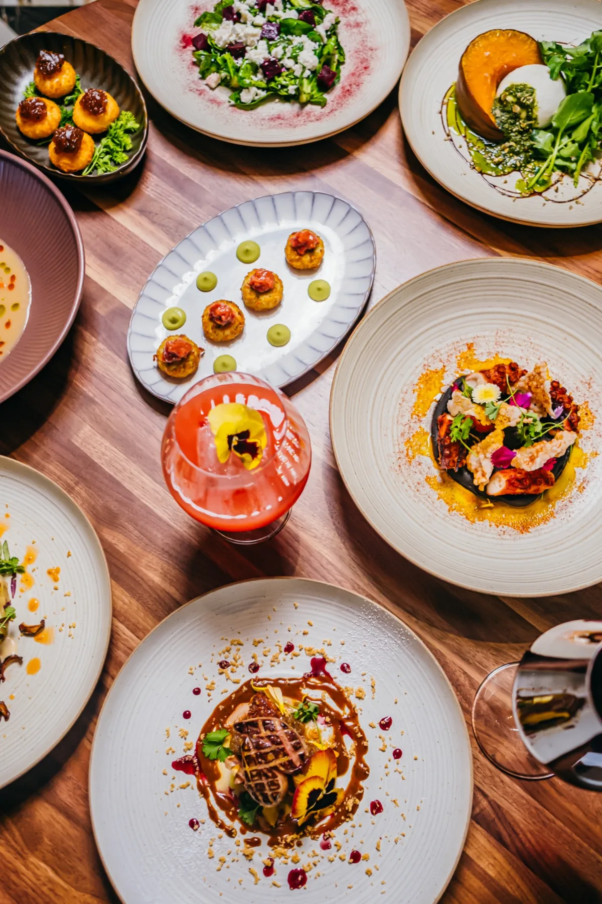 Overhead dining table with cocktails and plated dishes.