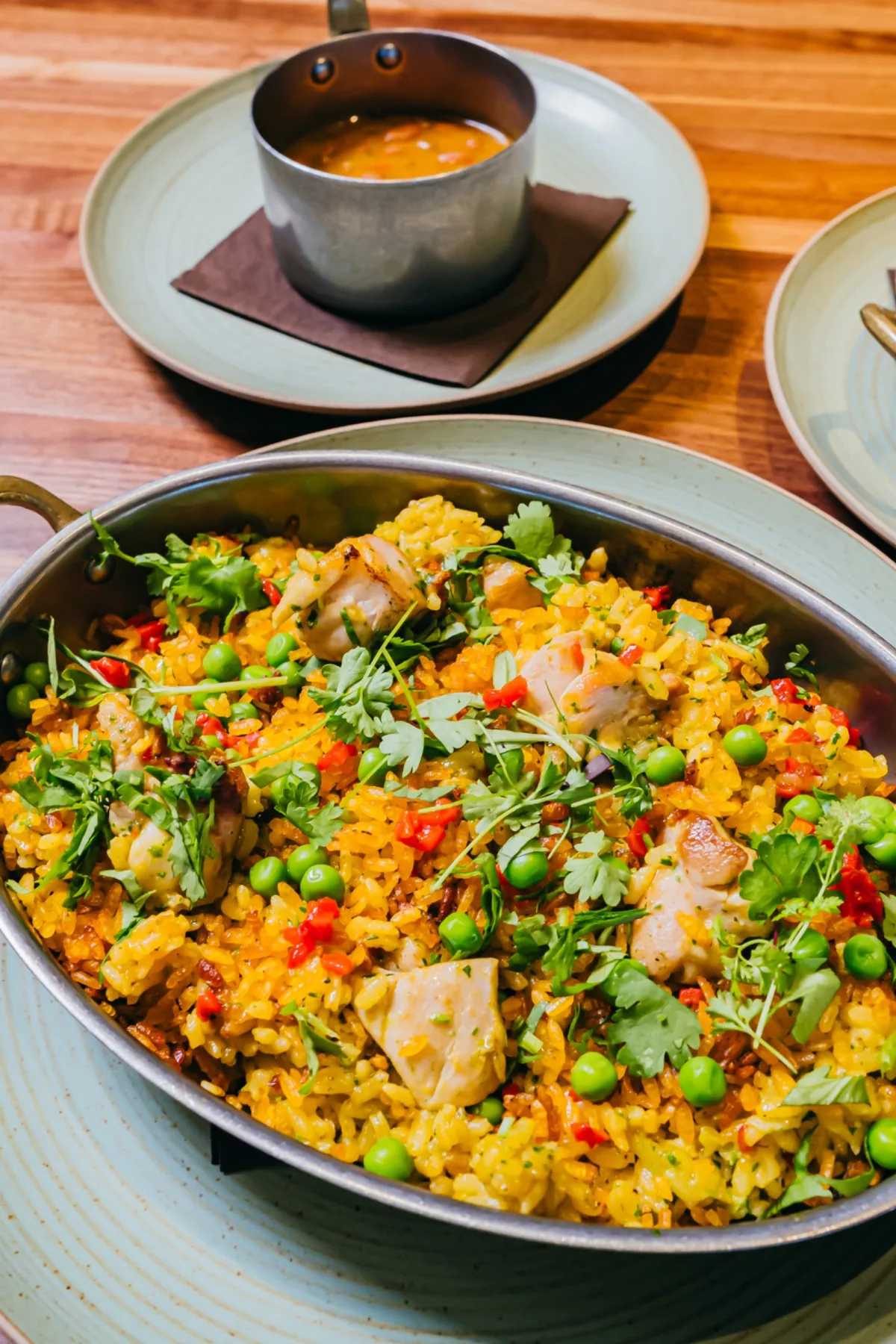 Skillet of chicken and colorful rice finished with herbs.