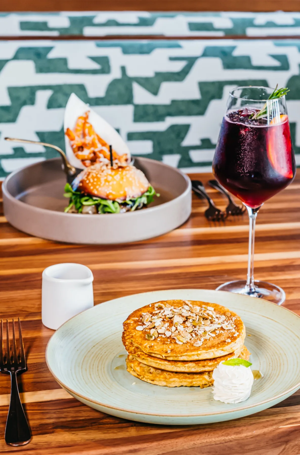 Brunch plate and a glass of red wine on a wood table.