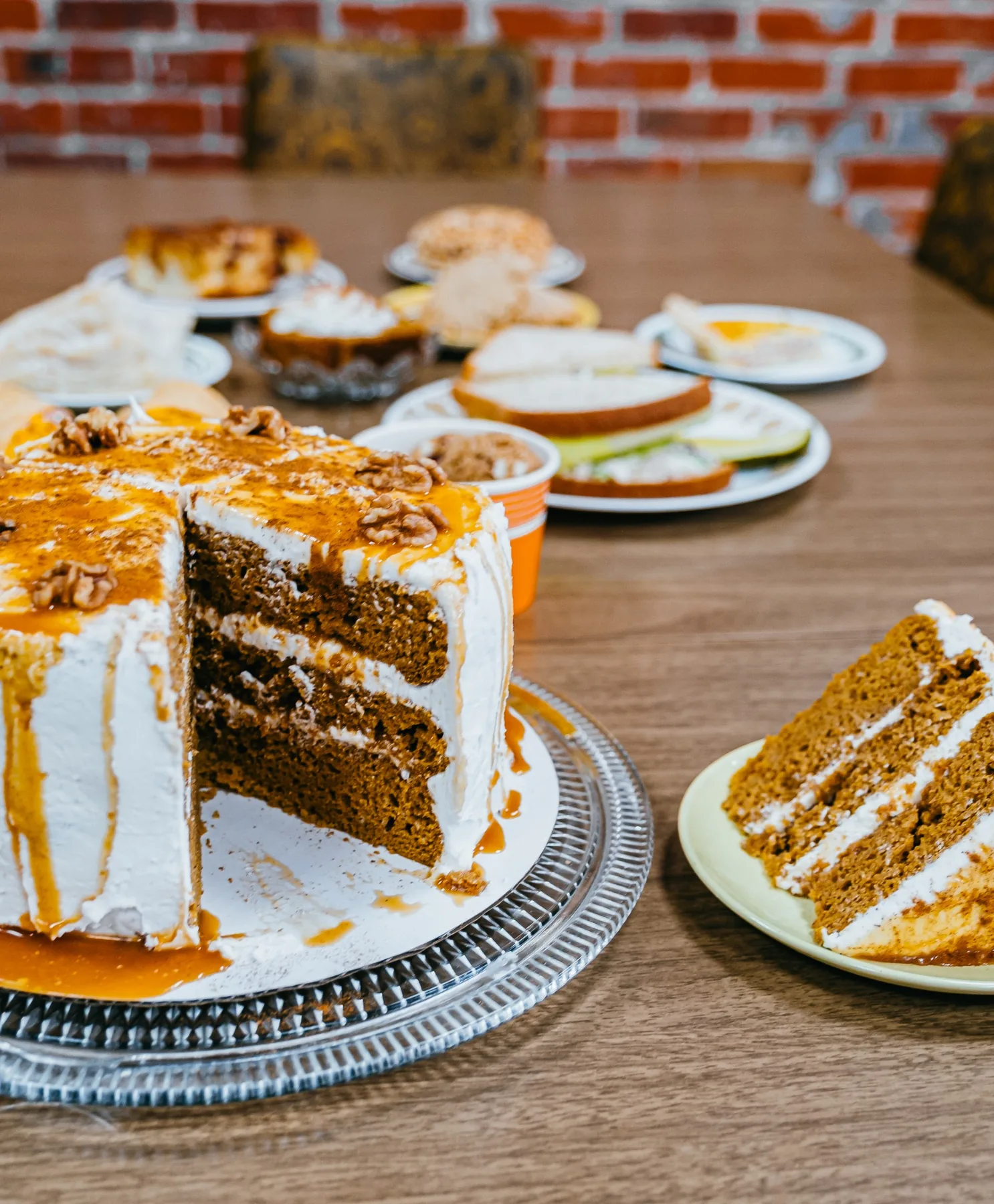 Tall slice of caramel layer cake beside a small plate of pastry.