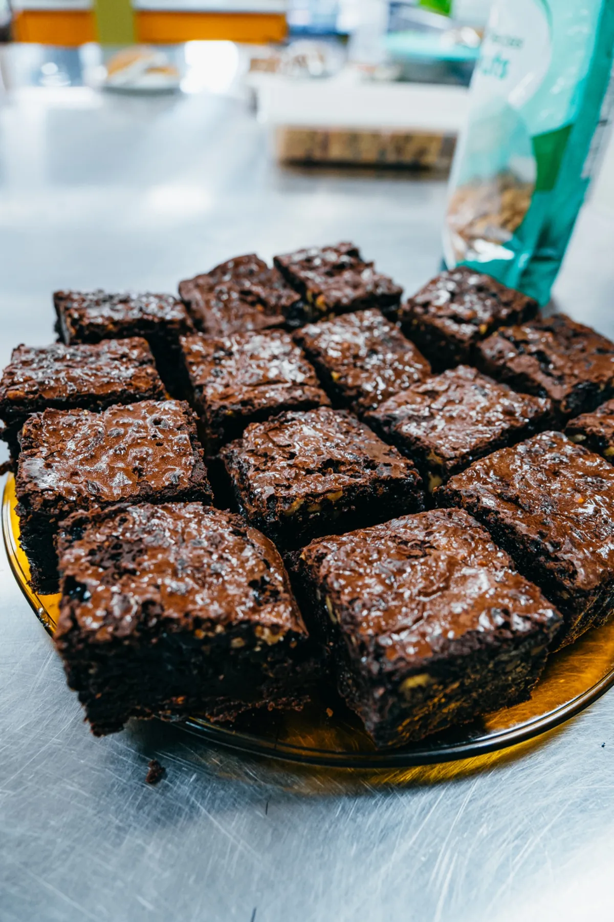 Tray of chocolate brownies finished with caramel drizzle and walnuts.