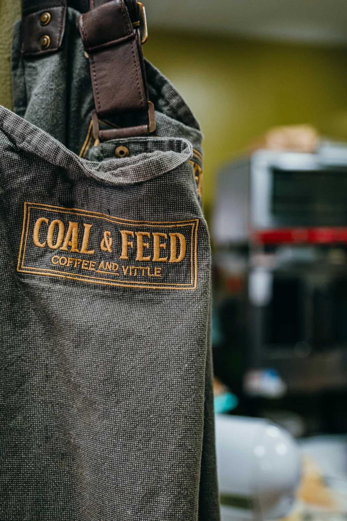 Coal and Feed logo patch stitched on a gray cafe apron.