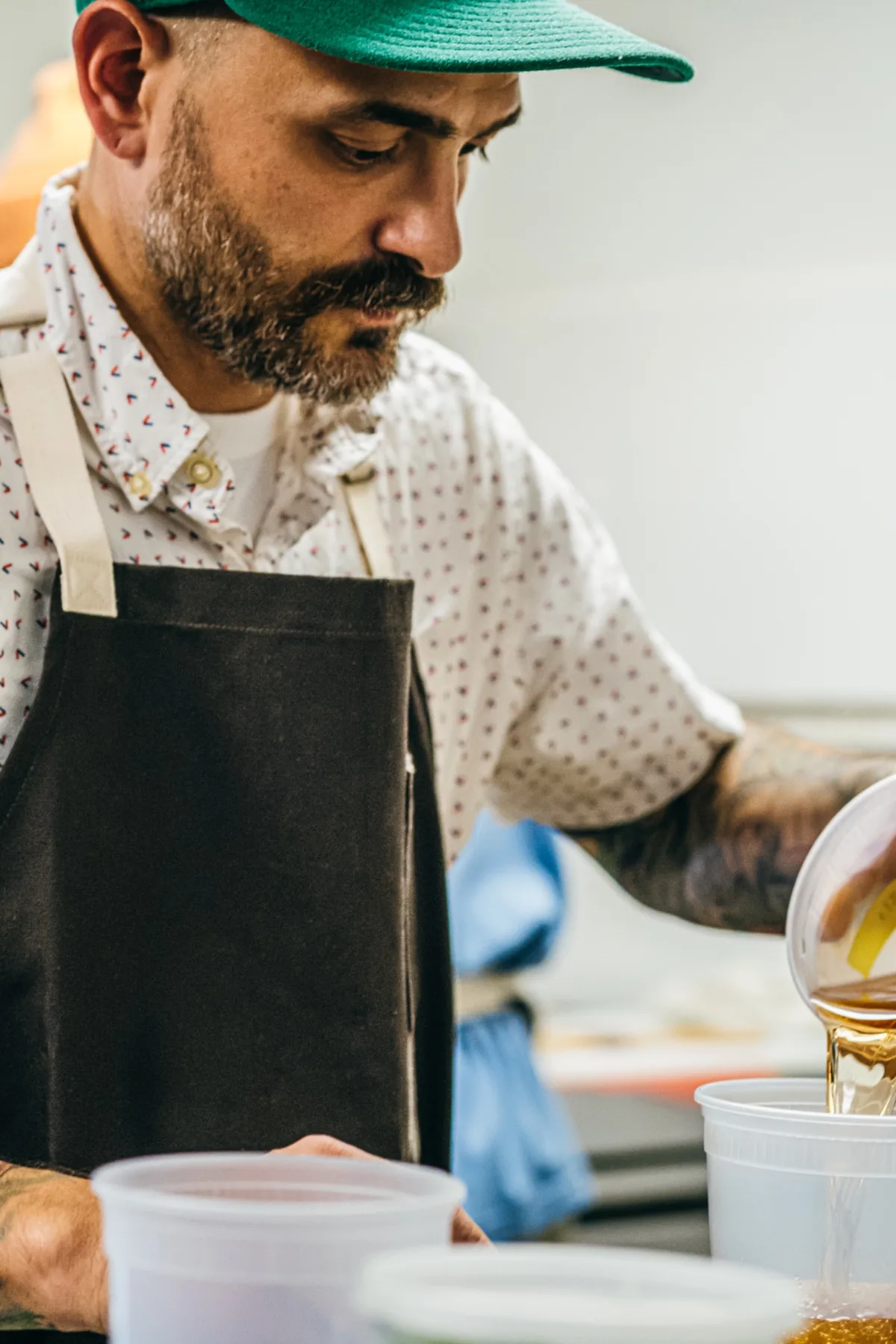 Close crop of a chef in a dark apron working at the pass.