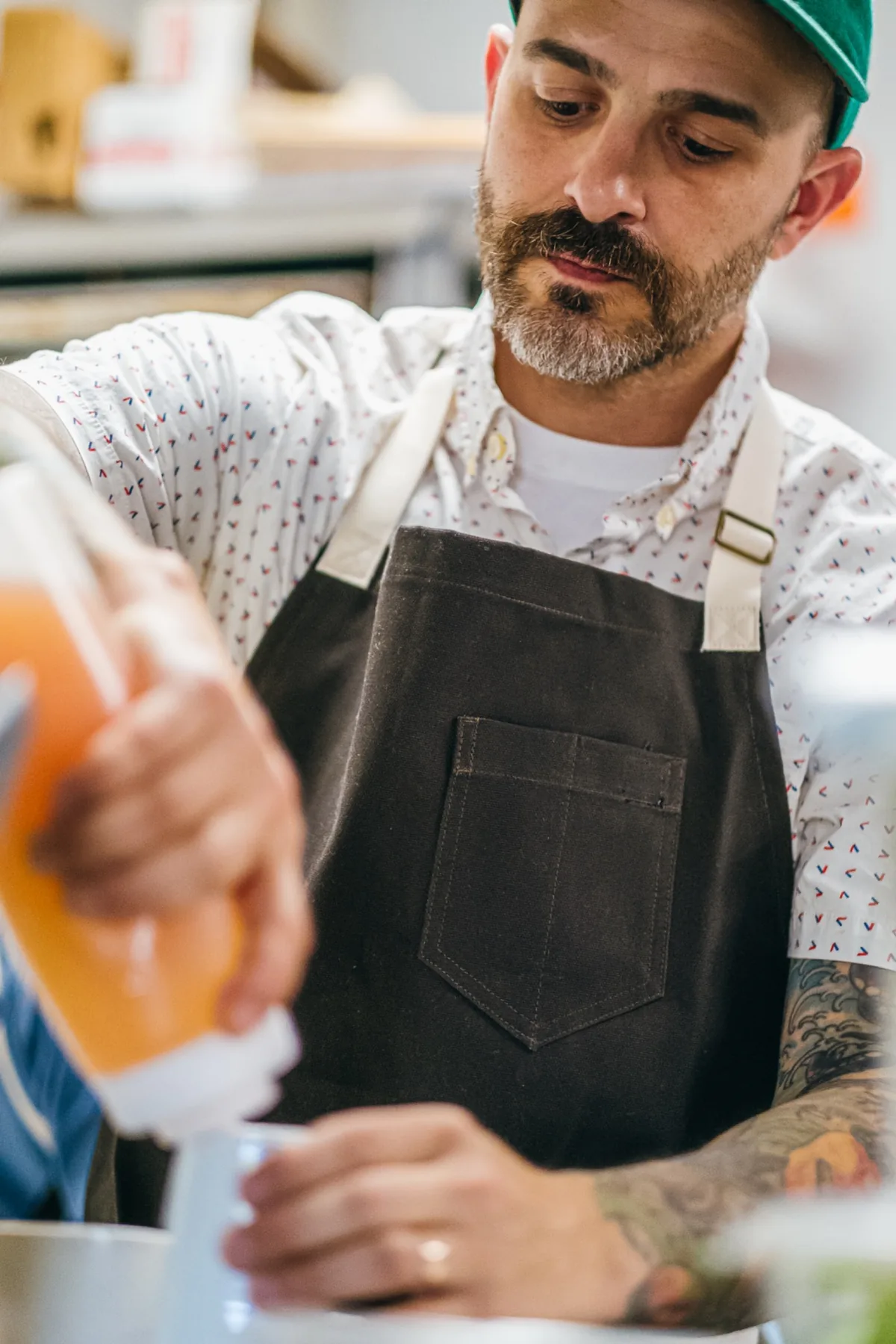 Close crop of a patterned shirt and dark kitchen apron.