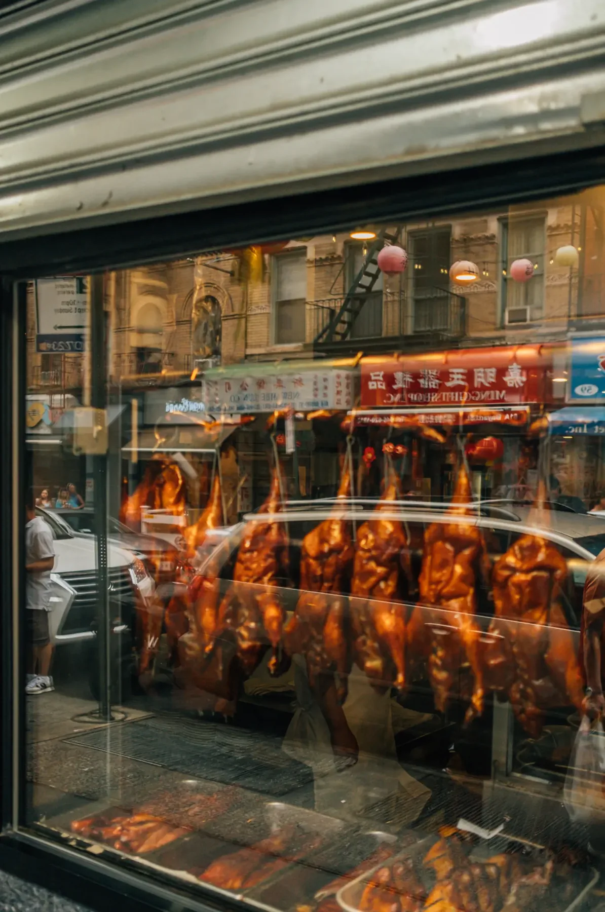 New York restaurant interior reflected in a rain-streaked storefront window.