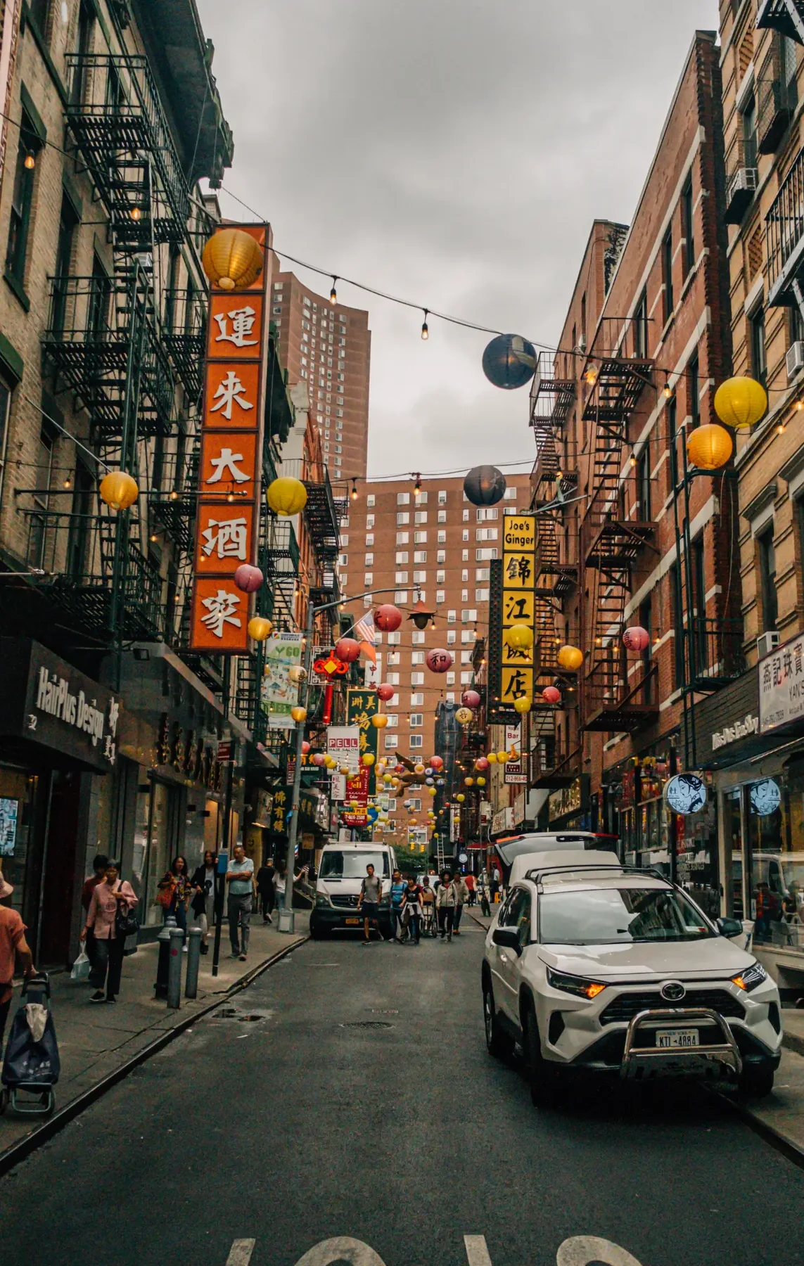 Chinatown street scene with traffic and dense storefronts.