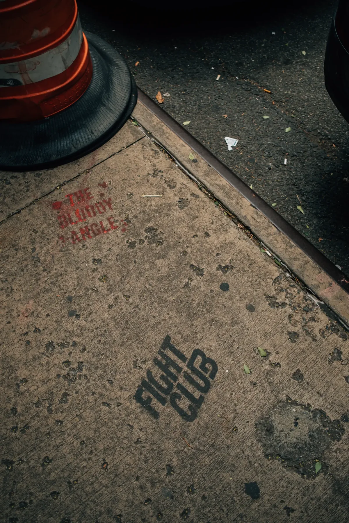 Worn New York City pavement marked with a hand-lettered message.