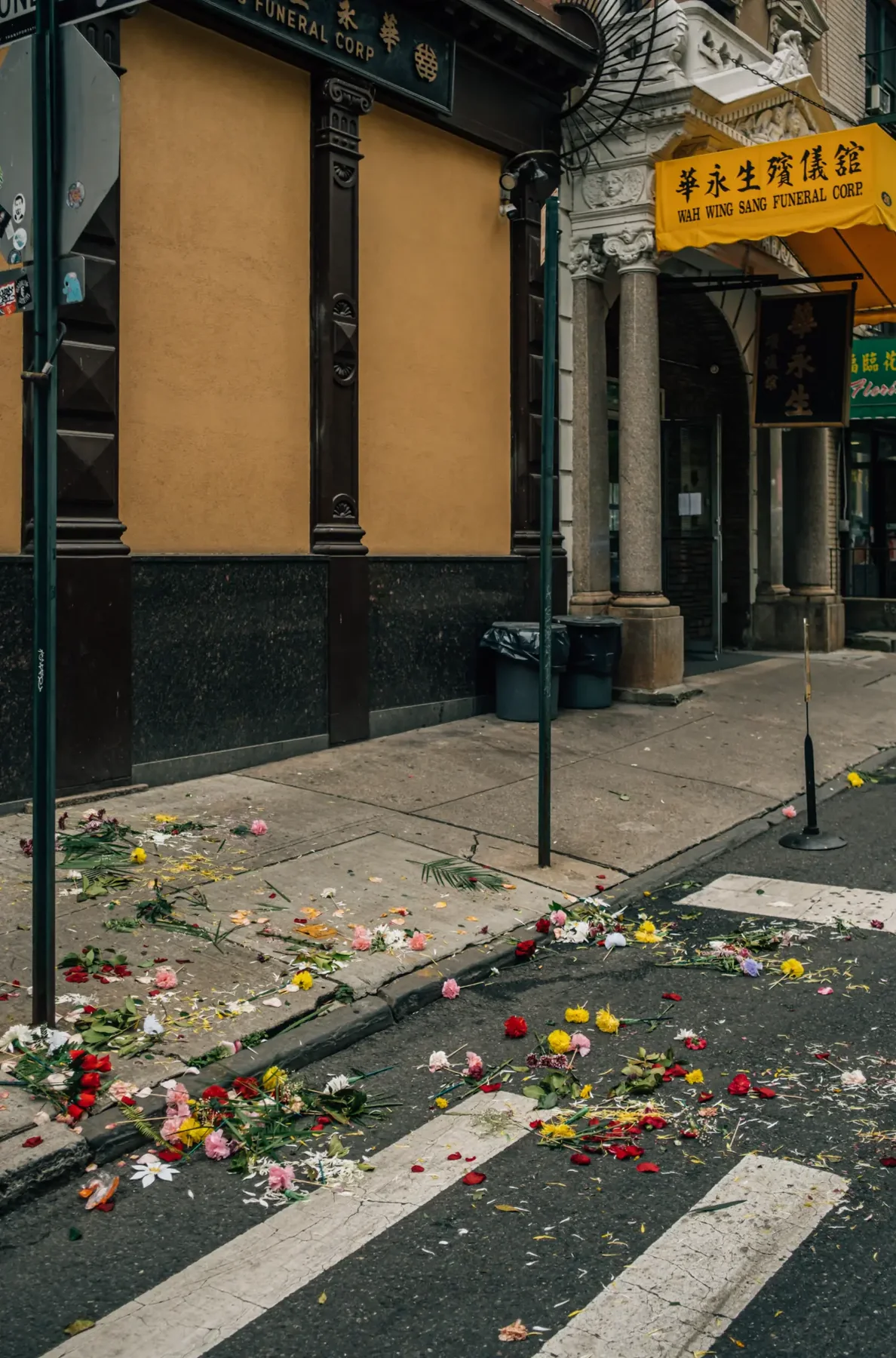 Chinatown storefront, street litter, and yellow market signage.